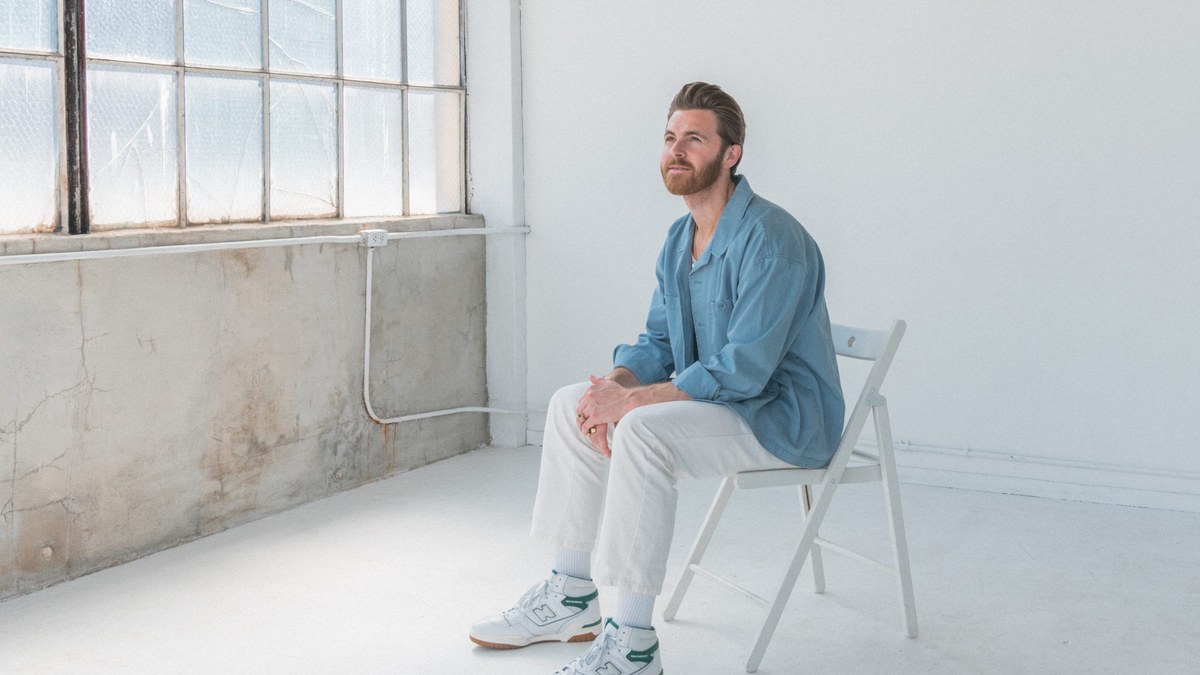 Jordan Tarver, author of You Deserve This Sh!t, sitting in a bright white studio